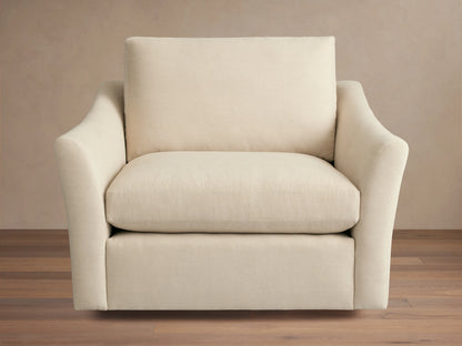Helena Swivel Chair in beige fabric, features gently curved armrests and a cushioned seat and backrest on a wooden floor background.