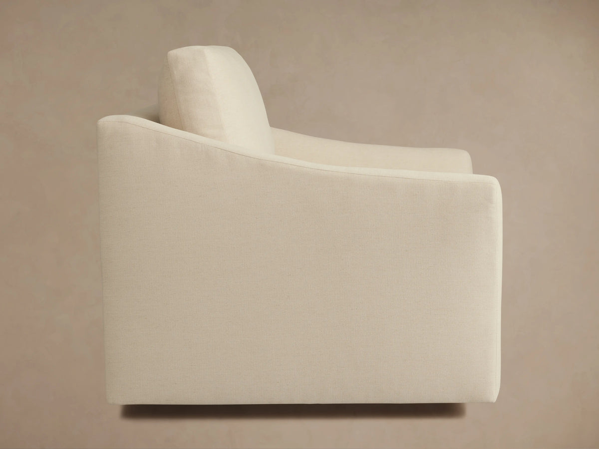 Alt text: Beige Helena Swivel Chair with a plush, cushioned seat and backrest. Features smooth armrests and a fabric exterior.