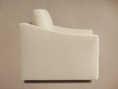 Alt text: Beige Helena Swivel Chair with a plush, cushioned seat and backrest. Features smooth armrests and a fabric exterior.
