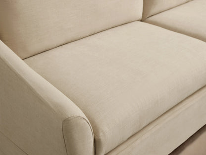 Helena Slipcovered Sofa in a beige fabric, featuring a clean silhouette, low arms, and plush cushions on a wooden floor.