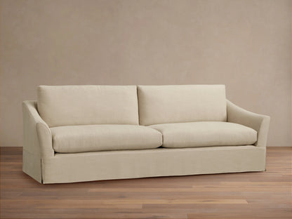 Beige Helena Slipcovered Sofa close-up showing the smooth, soft fabric texture, plush cushion, and rounded armrest design.