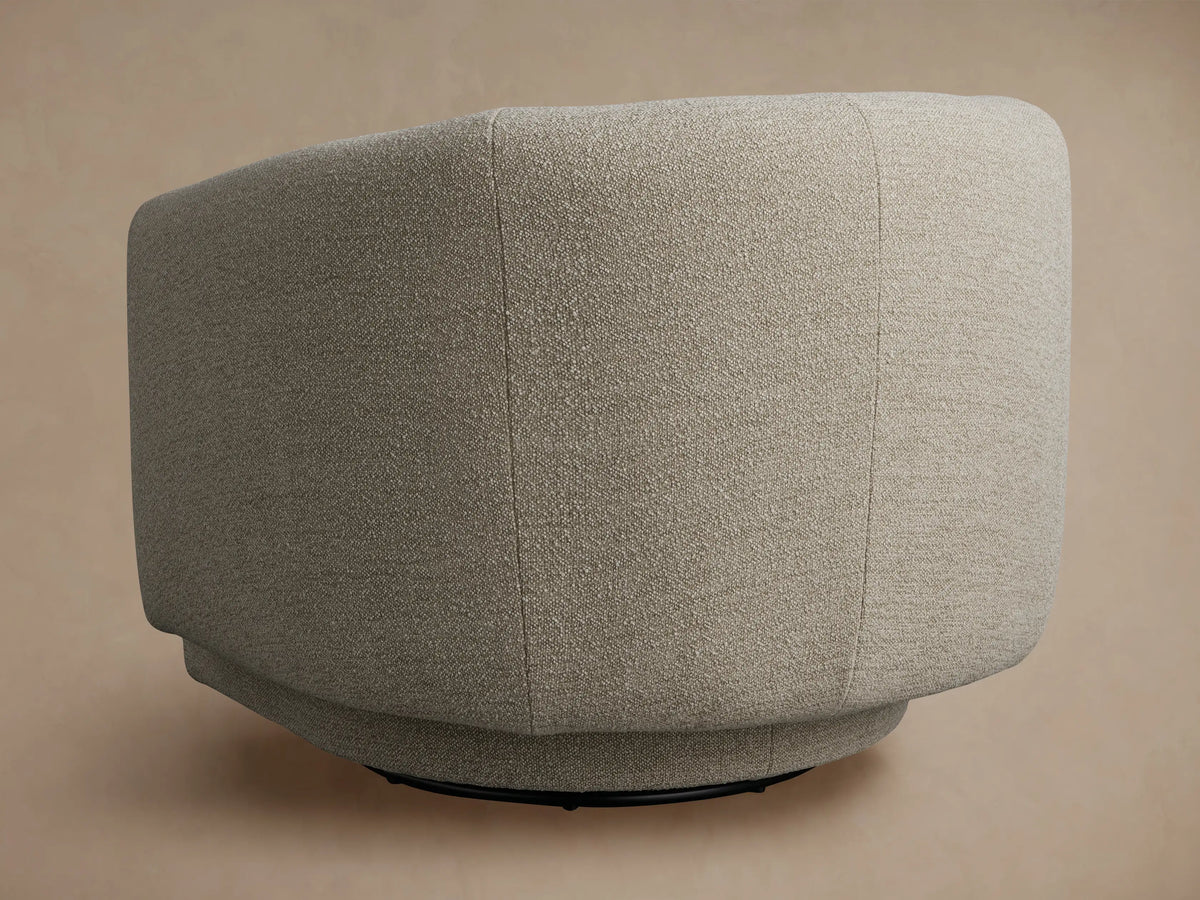 Close-up of the Hamlin Swivel Chair's curved armrest and back, featuring a light beige, subtly textured upholstery fabric.