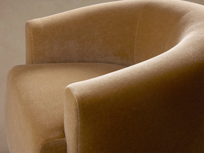 Front-on view of a plush, golden beige Hamlin Swivel Chair with a rounded, modern design, sitting on a hardwood floor.