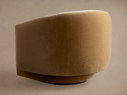 Close-up of the curved back and arm of a golden-brown velvet Hamlin Swivel Chair, showing soft texture and shadows.