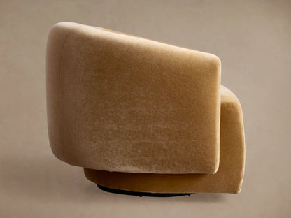 Hamlin Swivel Chair, upholstered in camel velvet, side view with a smoothly rounded back and seat, on a neutral background.