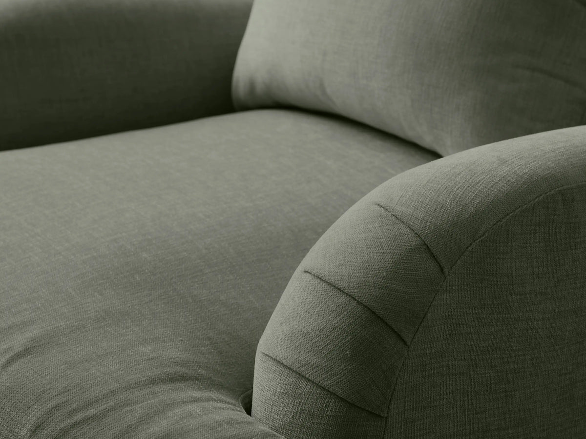 Hanover Chair: Green-grey upholstered armchair with padded, pleated rolled arms, loose back cushion, and turned wooden legs.