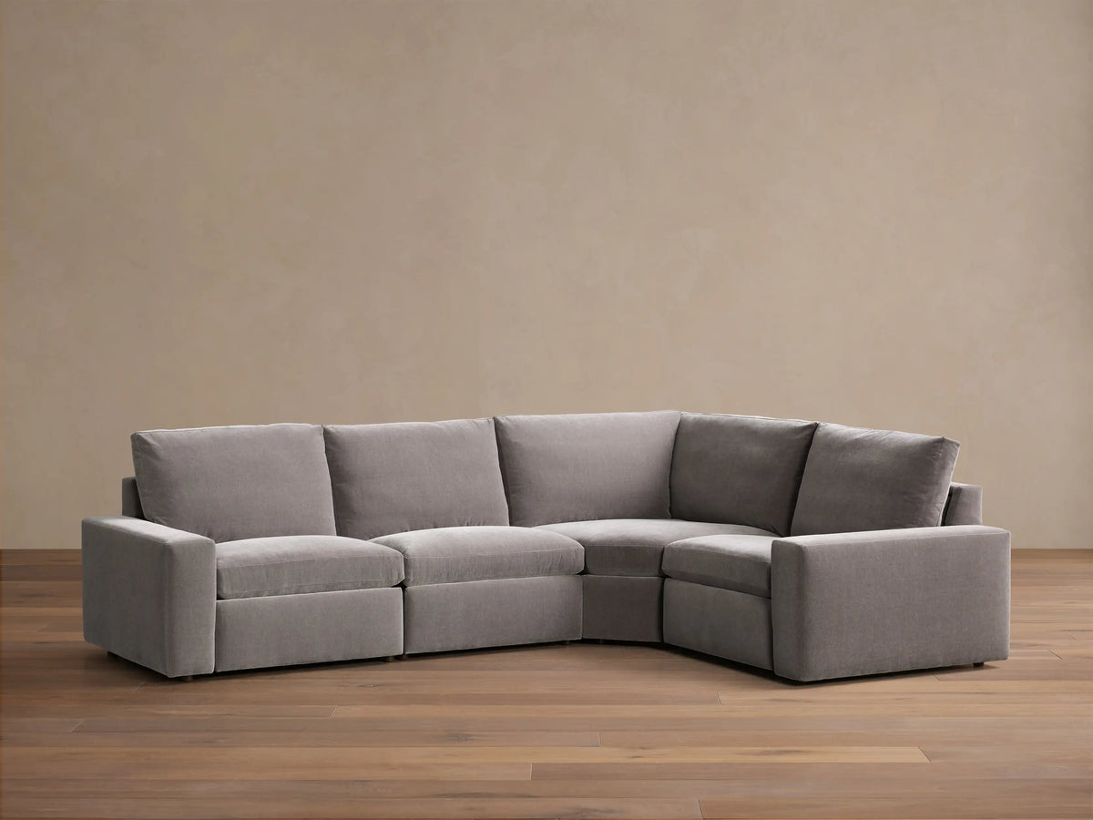 Front view of the grey Kipton Wide Arm Four-Piece Motion Sectional, an L-shaped sofa with plush cushions.