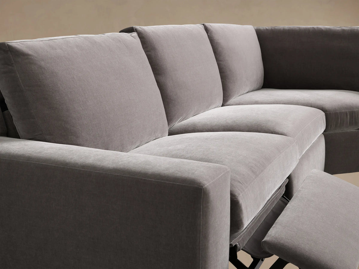 Close-up of the grey Kipton Wide Arm Four-Piece Motion Sectional's textured armrest with an oval taupe two-button motion control.