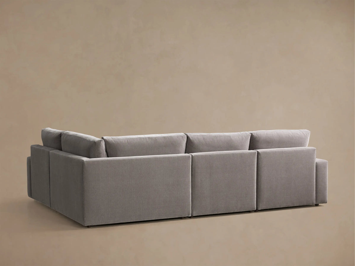 Close-up of the grey Kipton Wide Arm Four-Piece Motion Sectional, showing a wide arm and an extended footrest on a reclining seat.