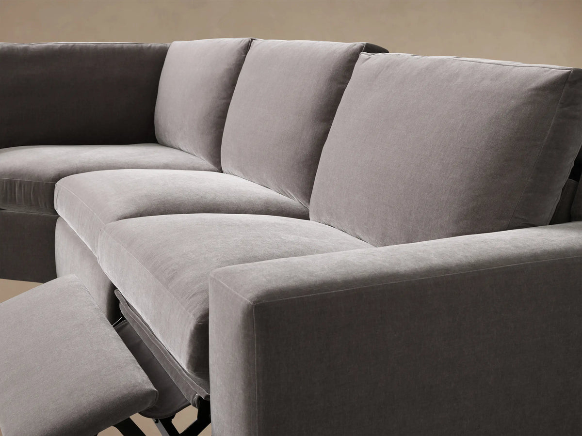 Close-up of the dark gray Kipton Wide Arm Four-Piece Motion Sectional, showing the metallic two-button motion control on the wide arm.