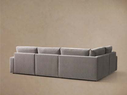 Close-up of a grey upholstered Kipton Wide Arm Four-Piece Motion Sectional with its footrest extended.