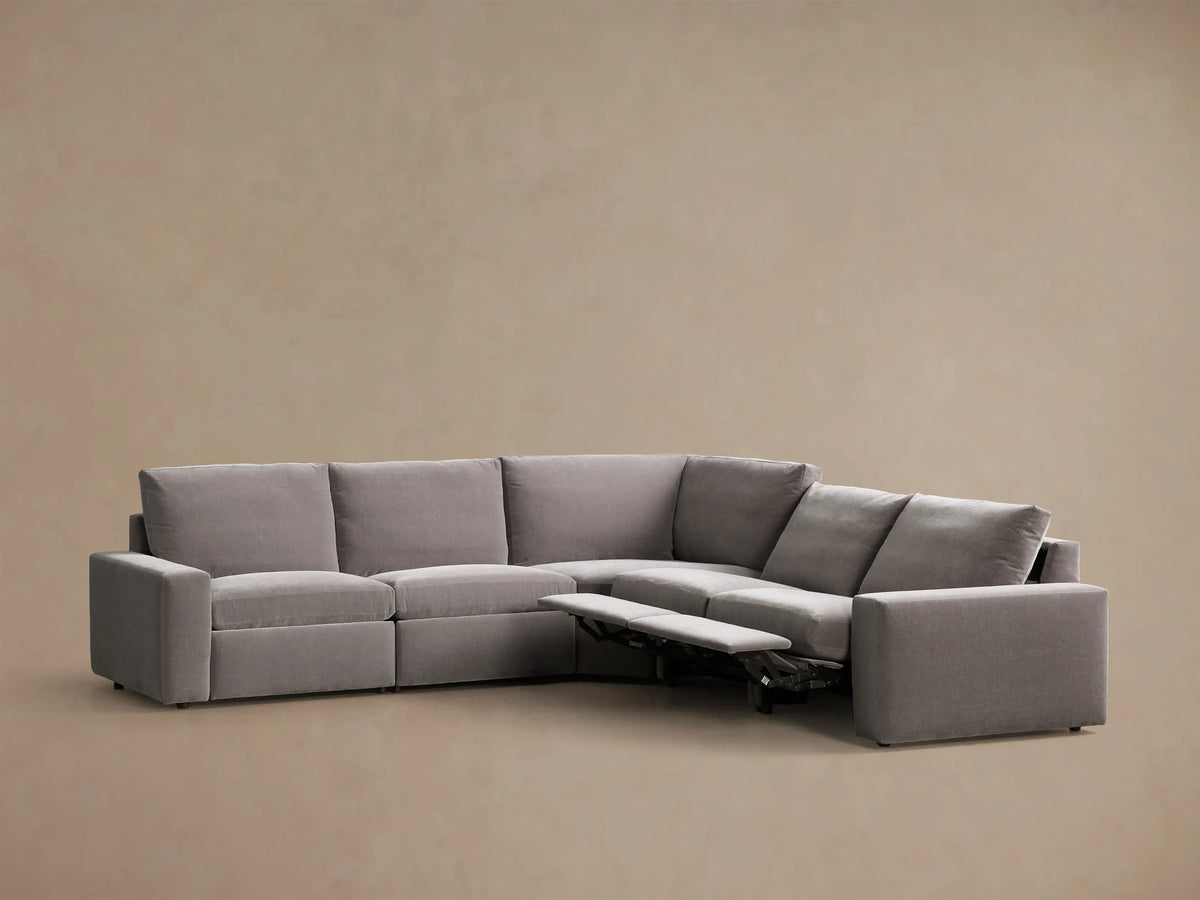 Front view of the gray Kipton Wide Arm Five-Piece Motion Corner Sectional, L-shaped with one footrest extended.