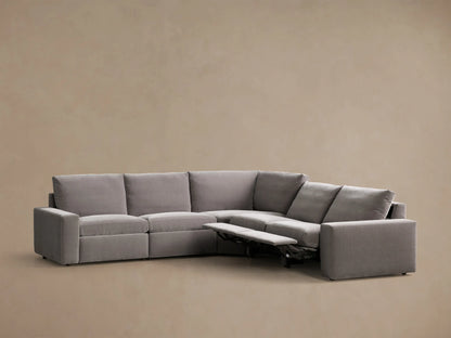 Front view of the gray Kipton Wide Arm Five-Piece Motion Corner Sectional, L-shaped with one footrest extended.