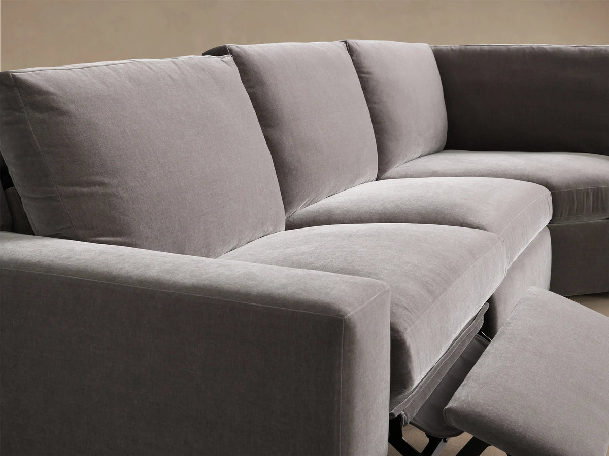 Close-up of gray Kipton Wide Arm Five-Piece Motion Corner Sectional with an extended footrest, plush cushions, and wide arms.