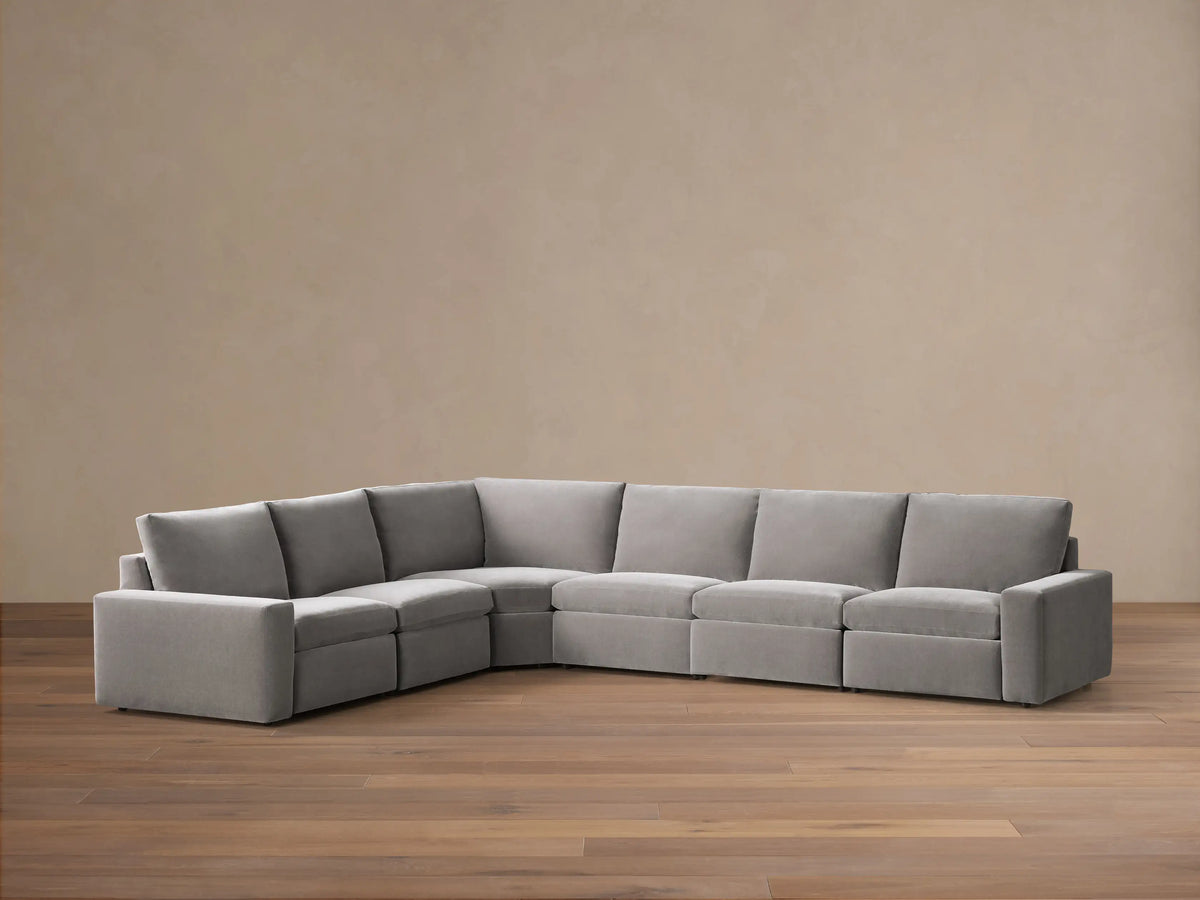 Front view of the gray Kipton Wide Arm Six Piece Motion Sectional, arranged in an L-shape with wide arms.