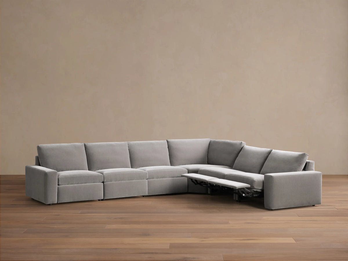 Front view of the gray Kipton Wide Arm Six Piece Motion Sectional, an L-shaped sofa with wide arms.