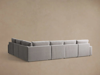Close-up of the light gray Kipton Wide Arm Six Piece Motion Sectional with its wide arm and extended motion footrest.