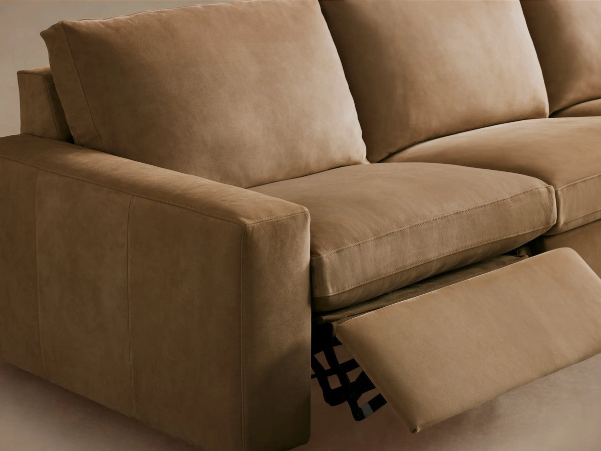 Kipton Wide Arm Nubuck Leather Three-Piece Motion Modular Sofa in brown, featuring wide arms, three cushions, and a wood floor setting.