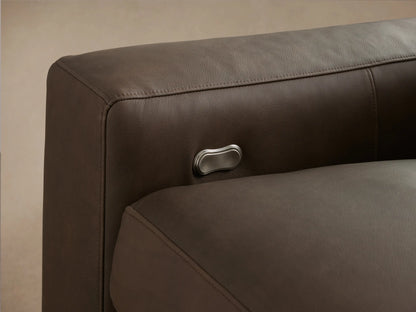 Kipton Wide Arm Leather Four-Piece Motion Sectional, dark brown, L-shaped, with wide arms, on a wooden floor.