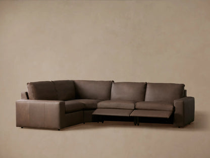 Rear-right view of Kipton Wide Arm Leather Four-Piece Motion Sectional. L-shaped, four-piece taupe leather sofa with raised back cushions.
