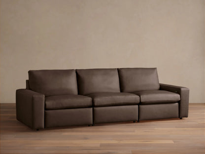 Kipton Wide-Arm Leather Three-Piece Motion Modular Sofa in rich dark brown, with plump cushions, on a wood floor.