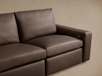 Kipton Wide-Arm Leather Sofa detail: rich brown leather, wide arm with silver motion control, and visible stitching.