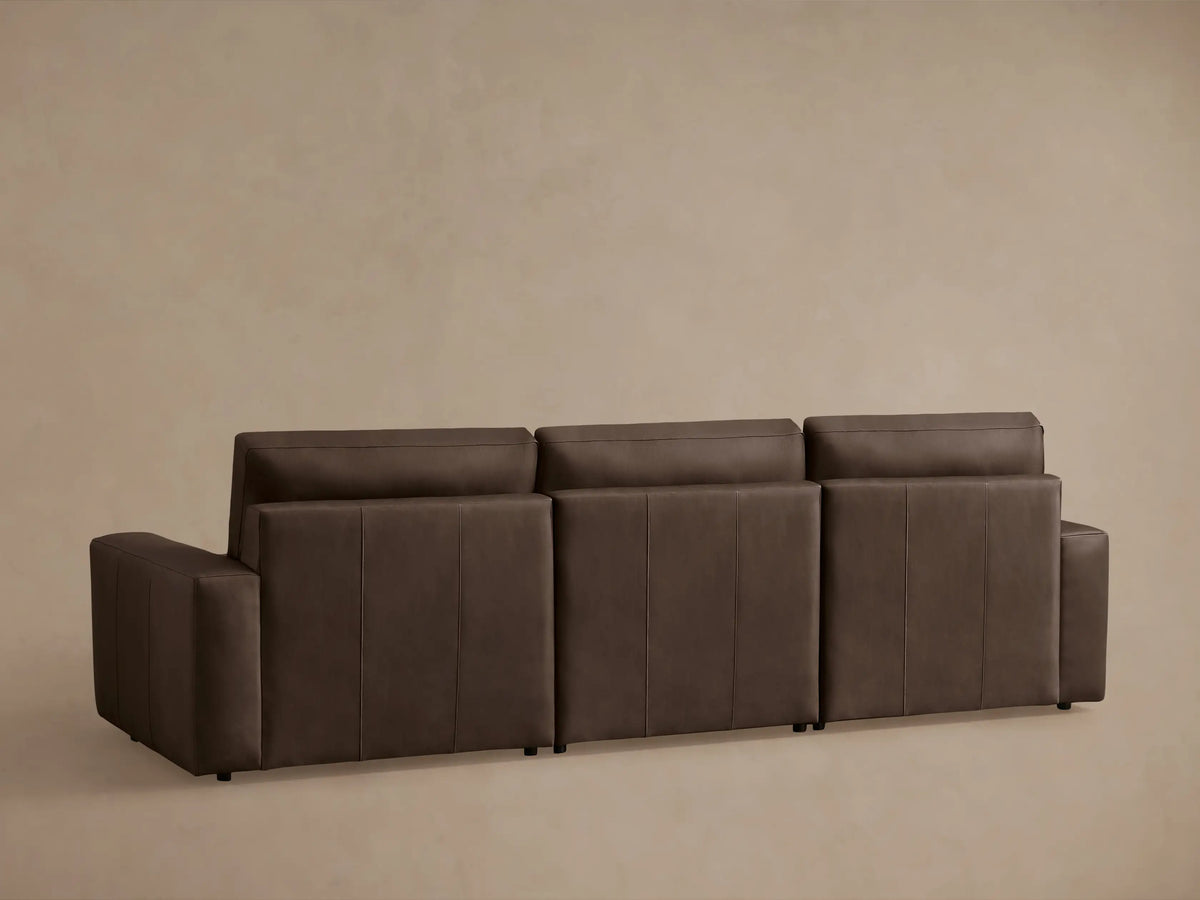 Close-up of a brown leather Kipton Wide-Arm Motion Modular Sofa, showing seat, back, and arm with motion control.