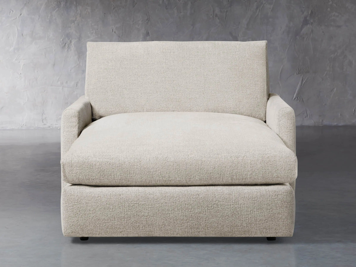 Front view of a light beige Kipton Slim Two Arm Chaise, featuring textured fabric, low arms, and an extended chaise seat.