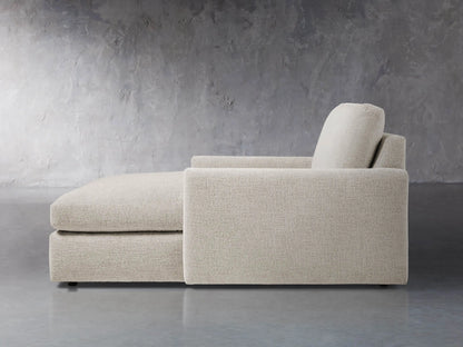 Close-up of the textured light grey fabric on the back cushion and armrest of the Kipton Slim Two Arm Chaise.