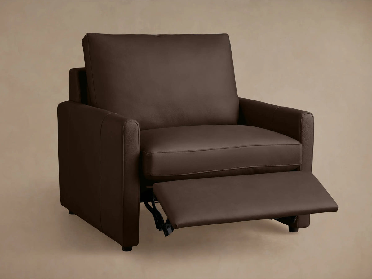 Kipton Leather Motion Recliner in dark brown leather, featuring slim arms and a cushioned seat and backrest, on wood floor. Front view.