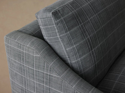 Kipton Slope Arm Sofa in charcoal gray plaid fabric with white lines, two back/two seat cushions, sloping arms, on wood floor.
