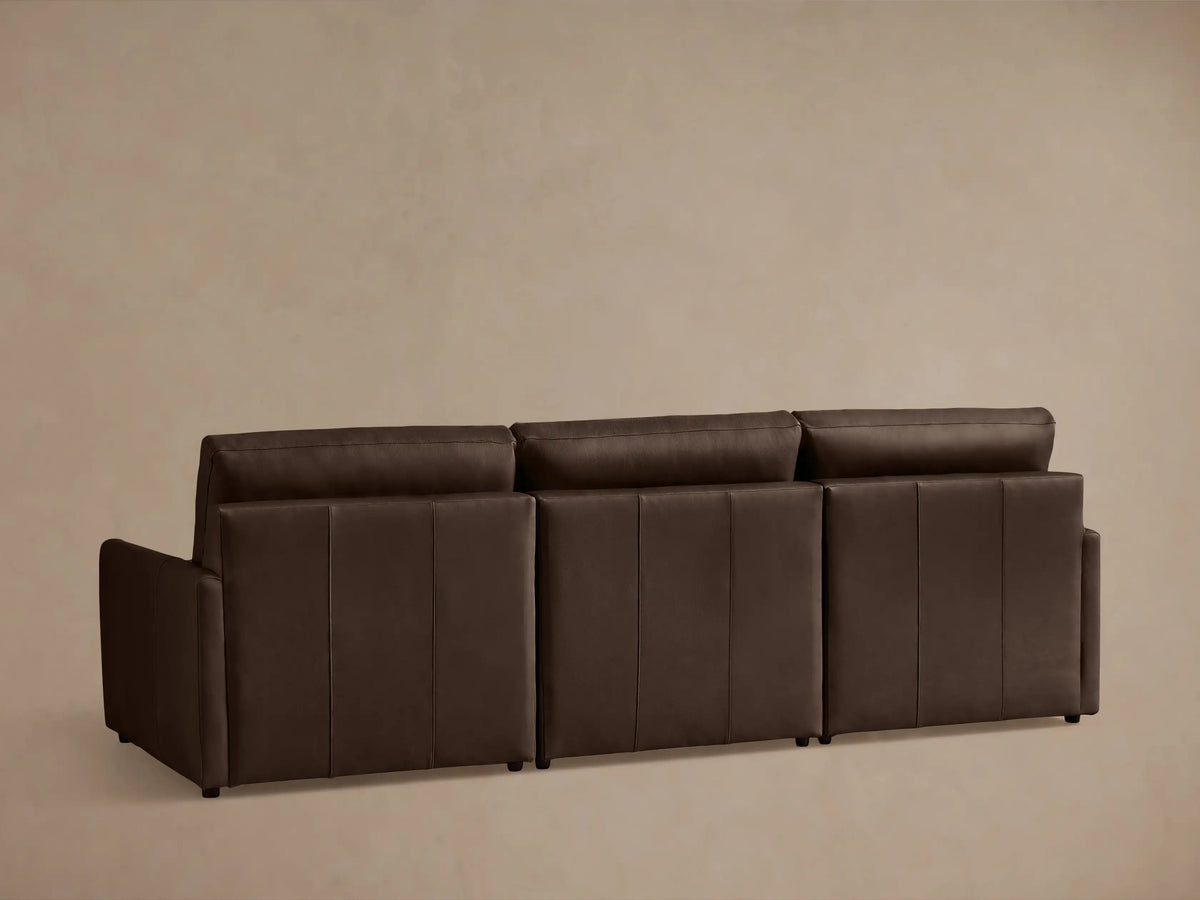Close-up of the Kipton Leather Three-Piece Motion Modular Sofa armrest in dark brown leather with visible two-button control.