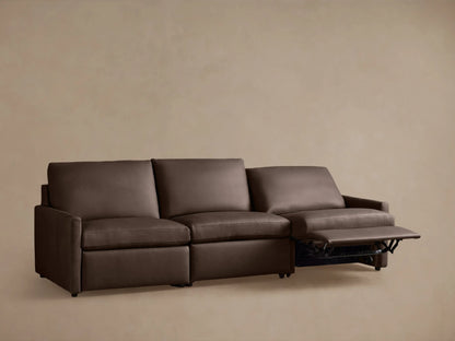Brown leather Kipton three-piece modular sofa on taupe background, two seats reclined. Slim arm design with plush cushions.