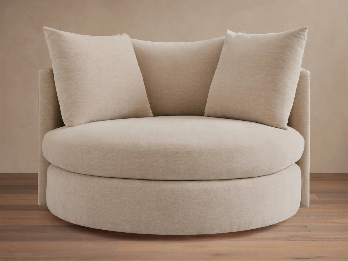 Kipton Oversized Swivel Chair in beige fabric, featuring a round seat, two plush back cushions, and a high backrest.