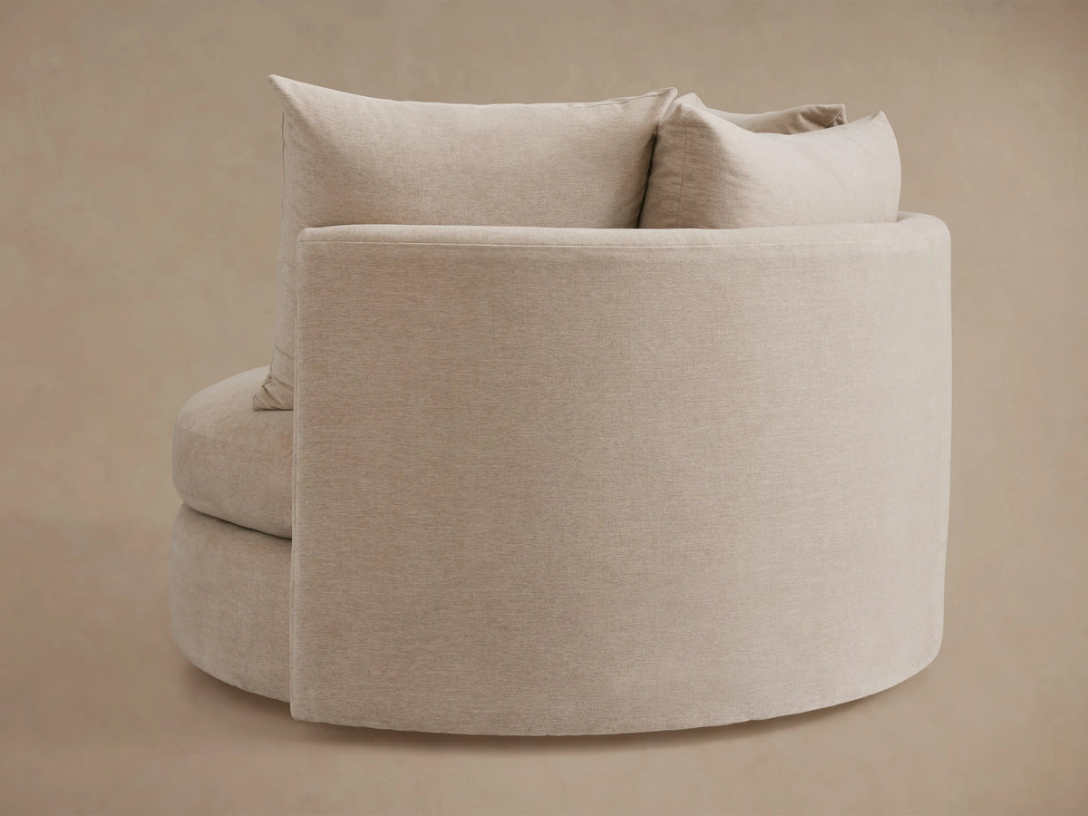Kipton Oversized Swivel Chair in beige fabric, showing a close-up of the cushioned seat and matching large back pillow.