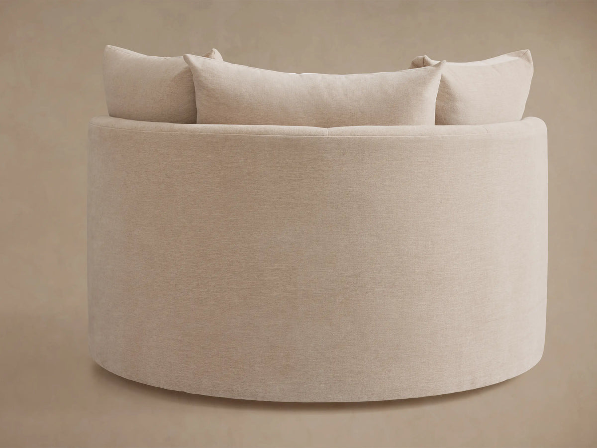 Kipton Oversized Swivel Chair in beige fabric, featuring a rounded back and plush cushions, against a neutral background.