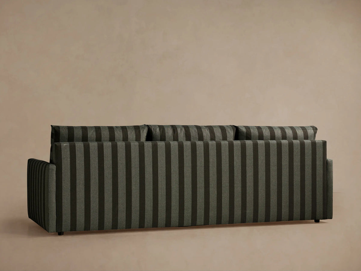 Close-up of Kipton Slim Arm Three-Seat Sofa. Dark green and brown vertical striped fabric covers cushions and slim armrest.