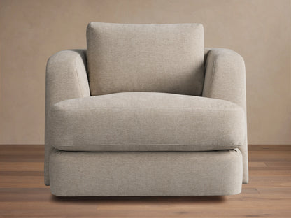 Kayden Swivel Chair with a beige fabric, plush seat, and back cushion. Features subtle rounded armrests and a sturdy swivel base on wooden floor.