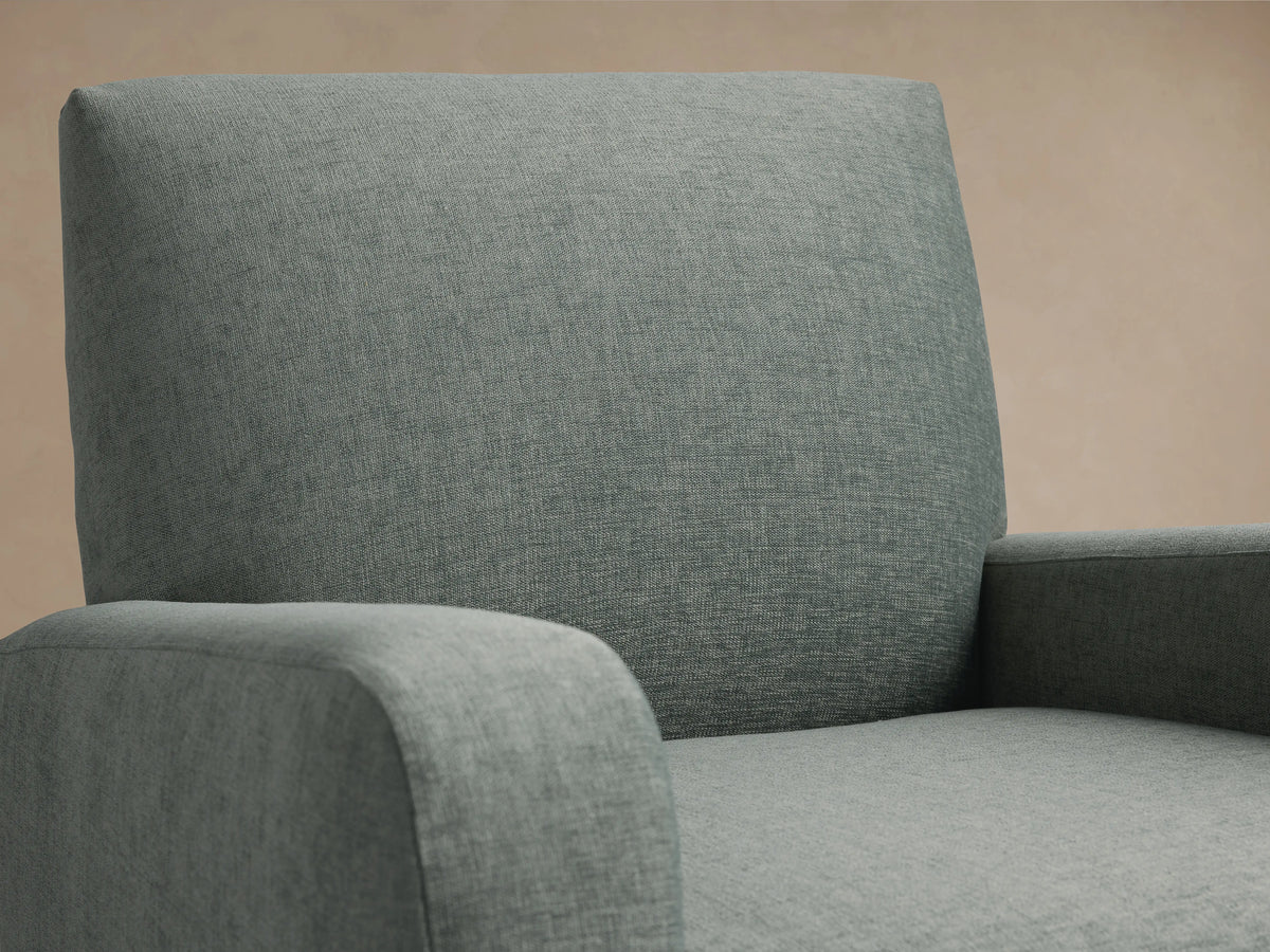 Gray Kershaw Swivel Chair with a square backrest, thick cushioned arms, and a solid base, on a wooden floor.
