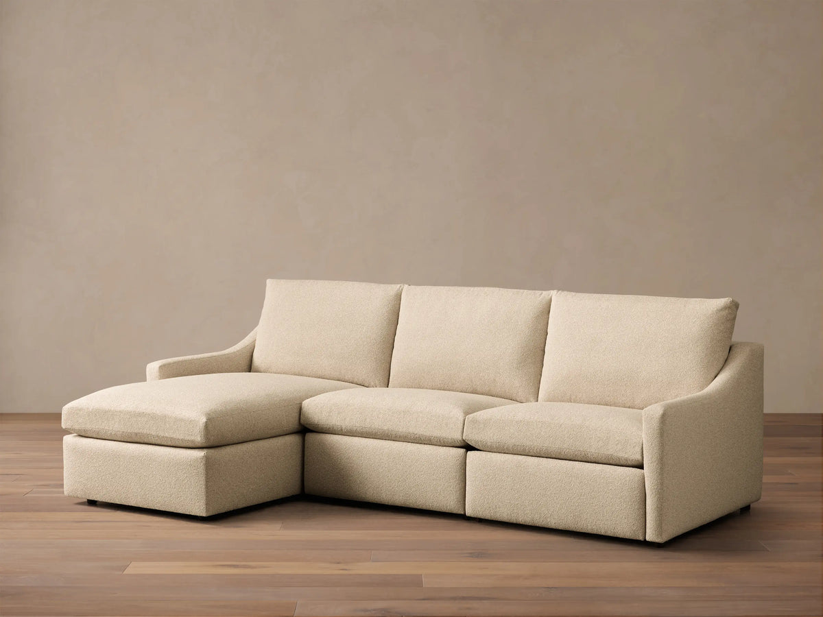 Front view of a light beige Kipton Slope Arm Three-Piece Motion Chaise Sectional with a left-facing chaise.