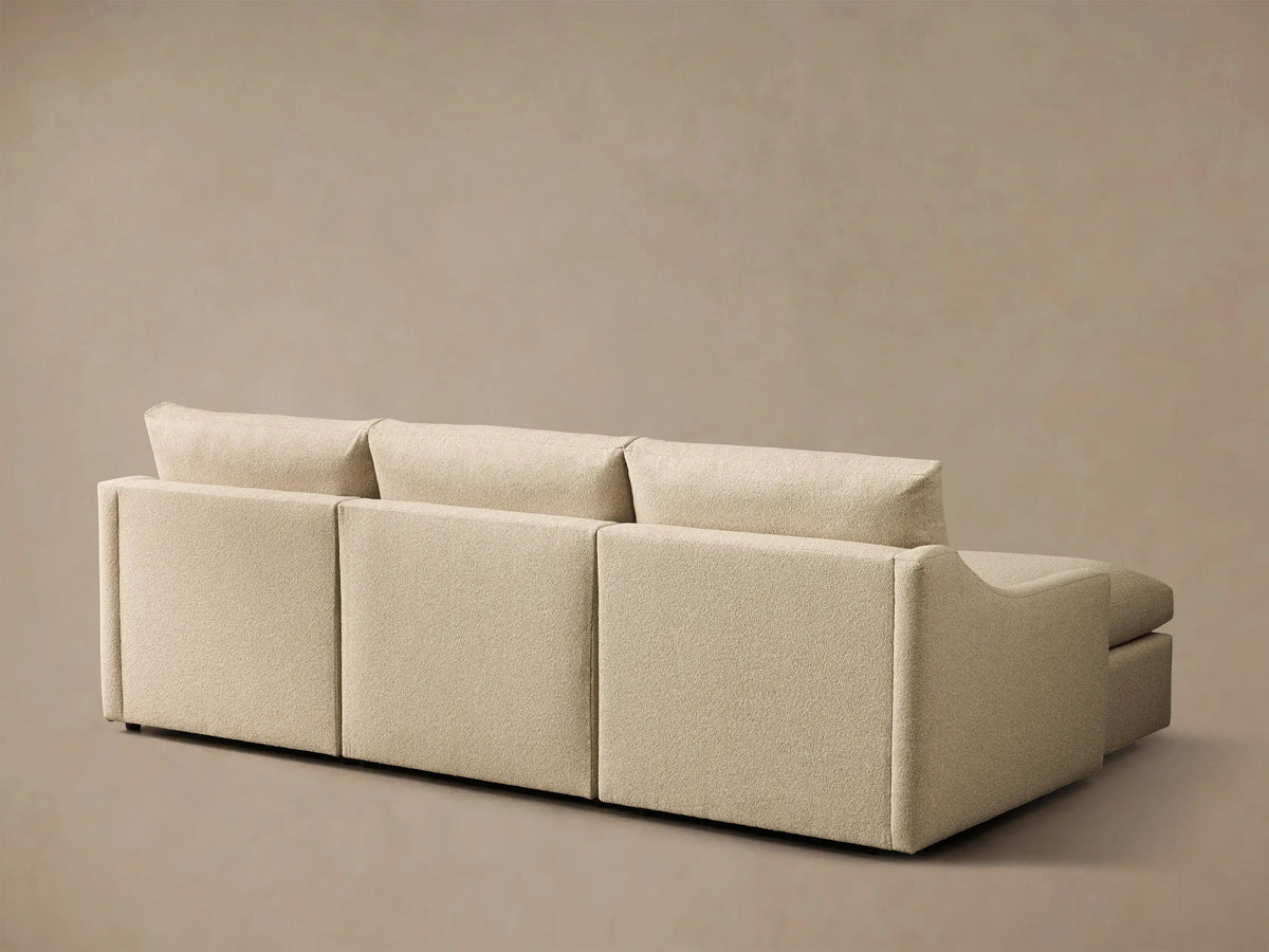 Close-up of the beige Kipton Slope Arm Three-Piece Motion Chaise Sectional, showing the textured fabric and extended footrest.