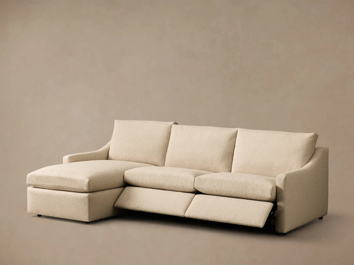 Rear view of the Beige Kipton Slope Arm Three-Piece Motion Chaise Sectional with three sections and plush back cushions.