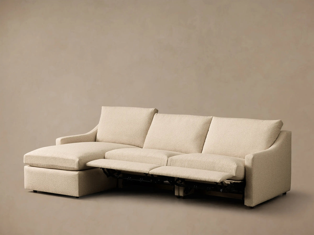 Front view of the cream Kipton Slope Arm Three-Piece Motion Chaise Sectional with two footrests extended.