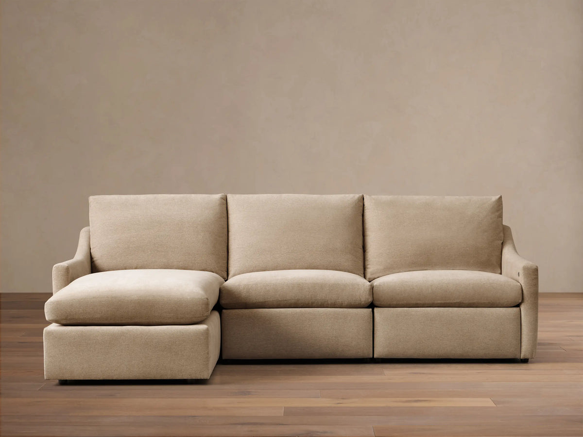 Front view of a light beige Kipton Slope Arm Three-Piece Motion Chaise Sectional™. It features a left-facing chaise and two motion recliners.
