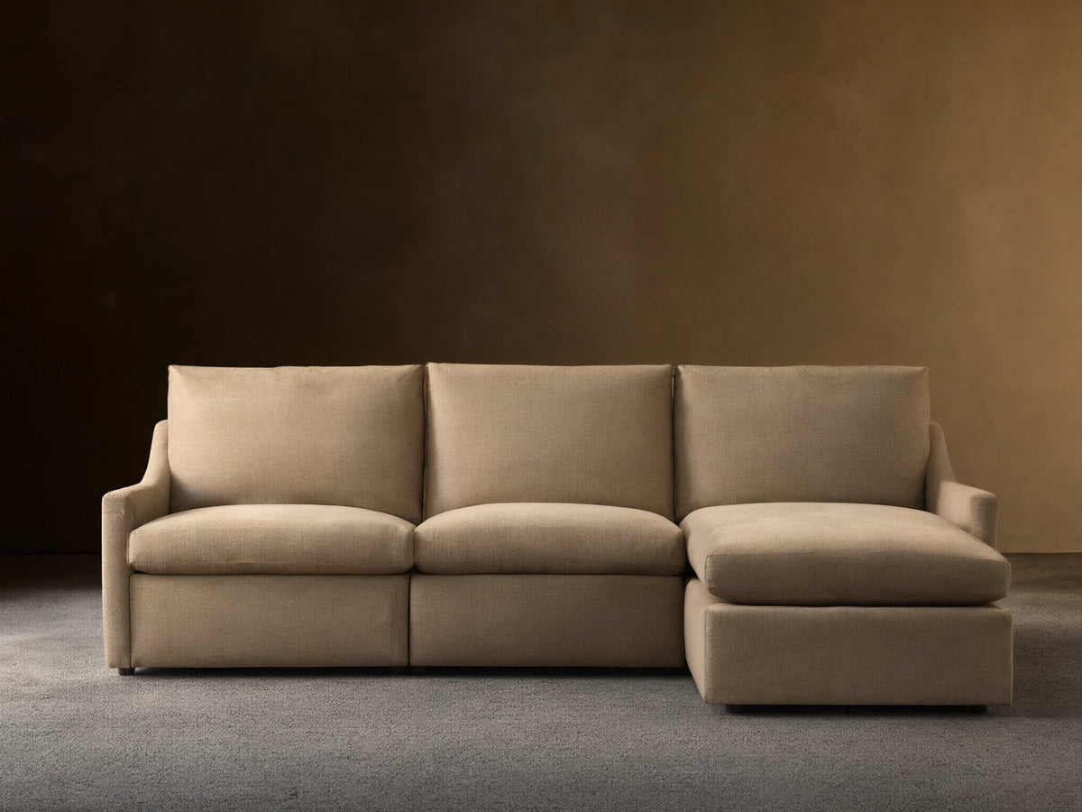 Front view of a light beige Kipton Slope Arm Three-Piece Motion Chaise Sectional™. It features a left-facing chaise and two motion recliners.