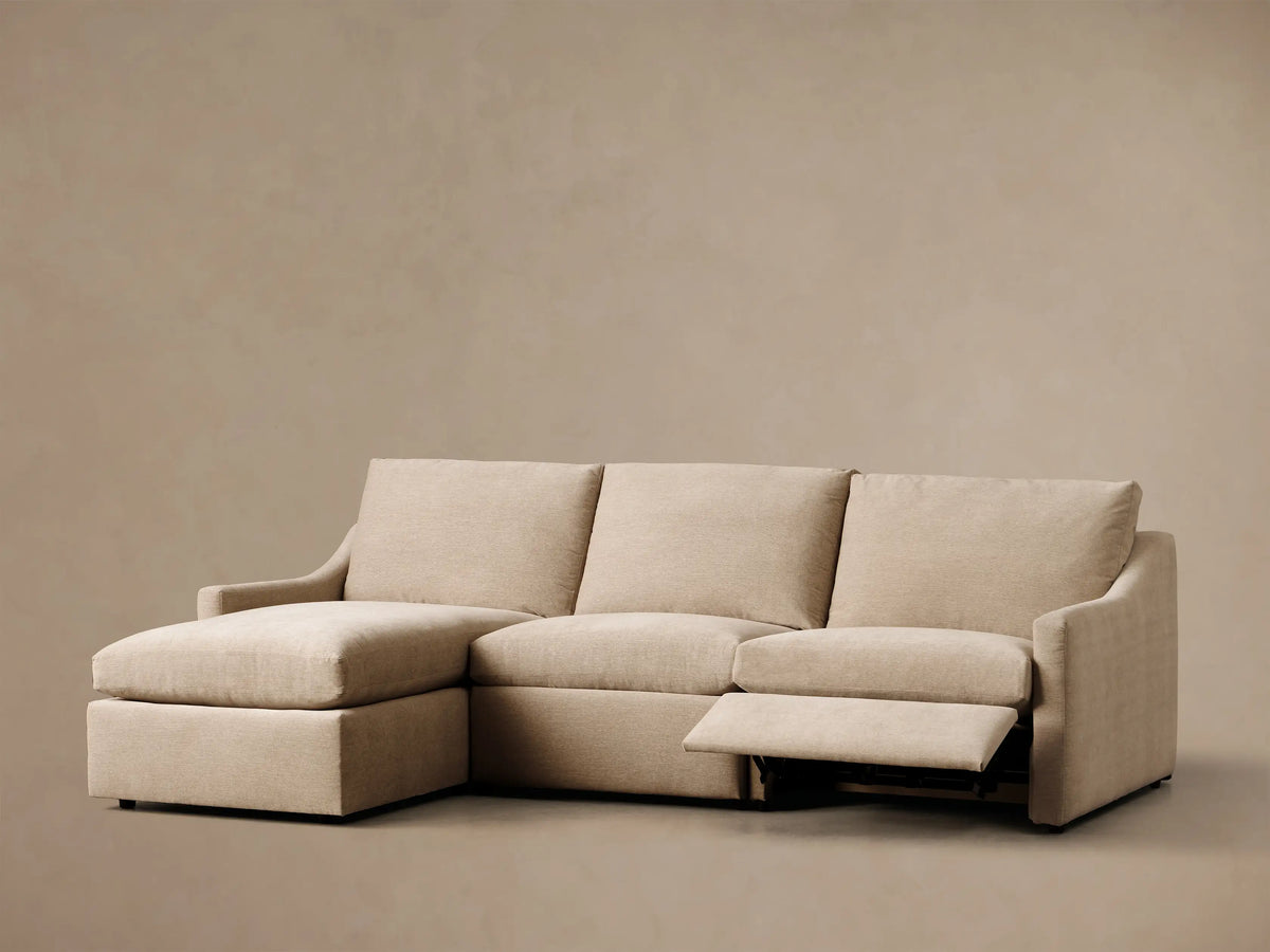 Front view of the light beige Kipton Slope Arm Three-Piece Motion Chaise Sectional with the middle footrest elevated.