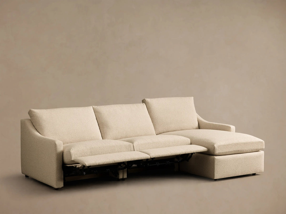Front view of Cream Kipton Slope Arm Three-Piece Motion Chaise Sectional with two footrests extended and right-facing chaise.