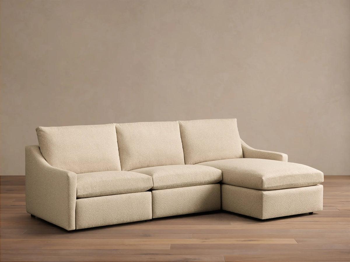 Front view of a Cream Kipton Slope Arm Three-Piece Motion Chaise Sectional, featuring three seat cushions and a right-facing chaise.