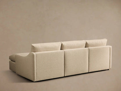 Rear view of the beige Kipton Slope Arm Three-Piece Motion Chaise Sectional, upholstered in textured fabric, showing modular backrests.