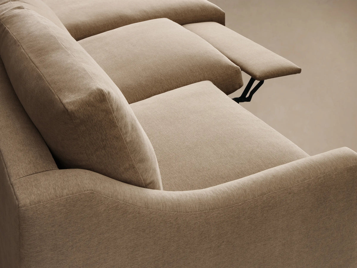 Close-up of beige Kipton Slope Arm Three-Piece Motion Chaise Sectional with an extended footrest and black support mechanism.
